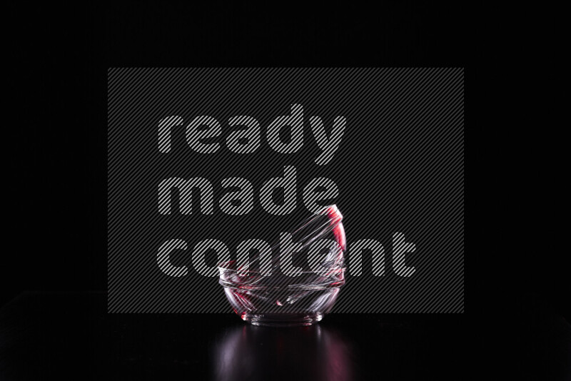 Glassware with rim light in red and white against black background