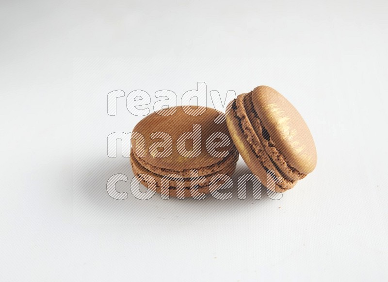 45º Shot of two Brown Coffee macarons on white background