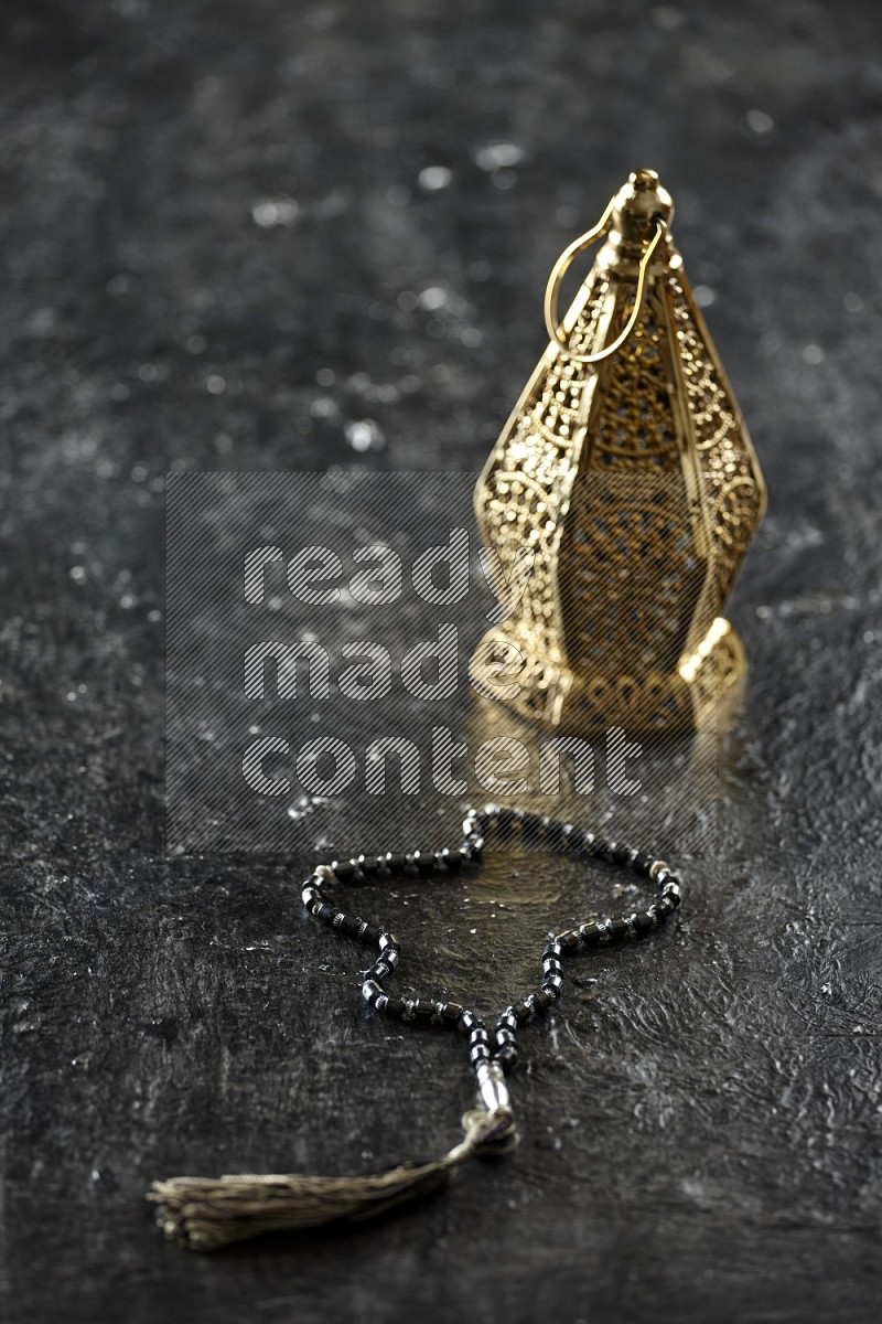 Quran with a prayer beads on textured black background