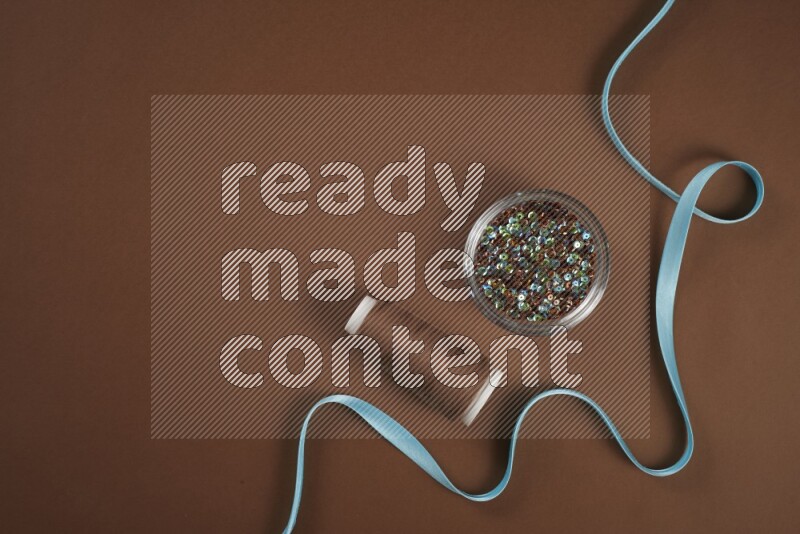 مجموعة من أدوات الخياطة والتفصيل زرقاء اللون على خلفية بنية