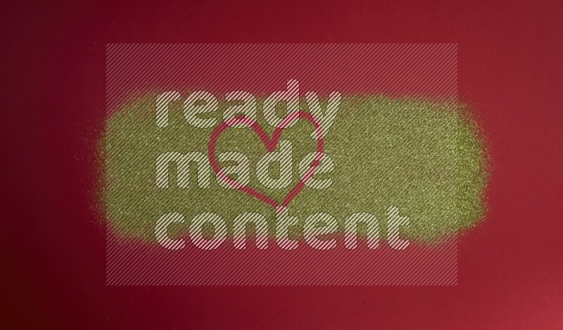 A heart drawn with gold glitter on red background