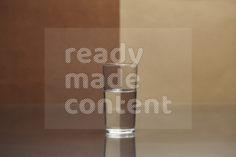 The image features a clear glassware filled with water, set against brown and beige background