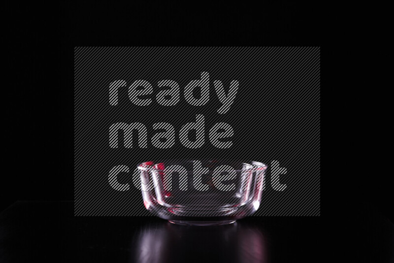 Glassware with rim light in red and white against black background