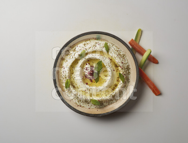 Lebnah garnished with zaater, mint & sumak in a pottery plate on a white background