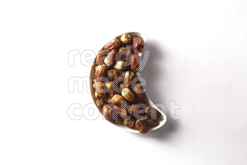 Dates in a crescent pottery plate on white background
