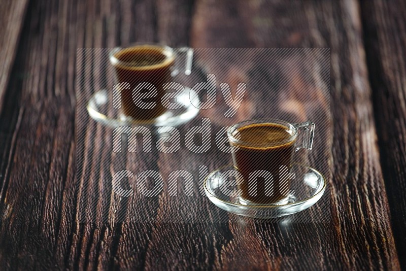 كوب زجاجي من القهوة مع التمر والشاي على خلفية خشبية