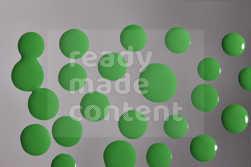 Close-ups of abstract green paint droplets on the surface
