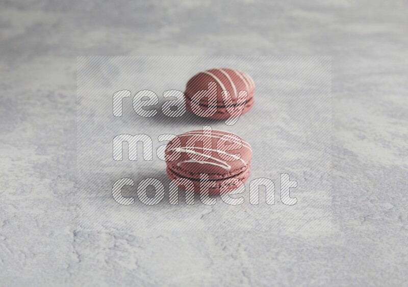 45º Shot of two Red Poppy Flower macarons on white  marble background