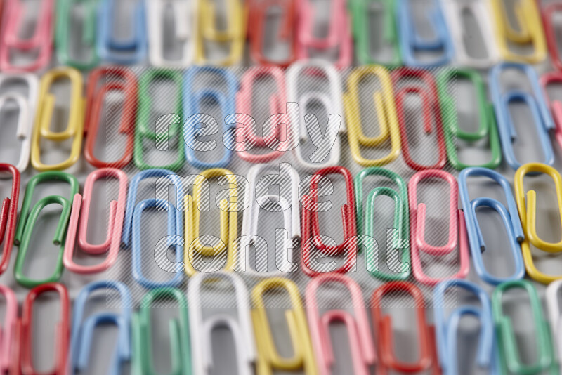 Multicolored paper clips isolated on a grey background