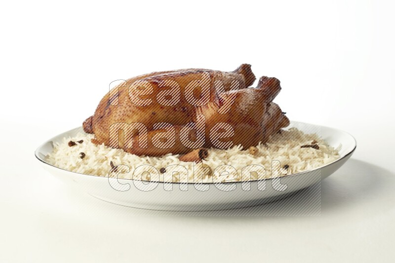 white  basmati Rice with  whole roasted chicken  on a white plate with a silver rim direct  on white background