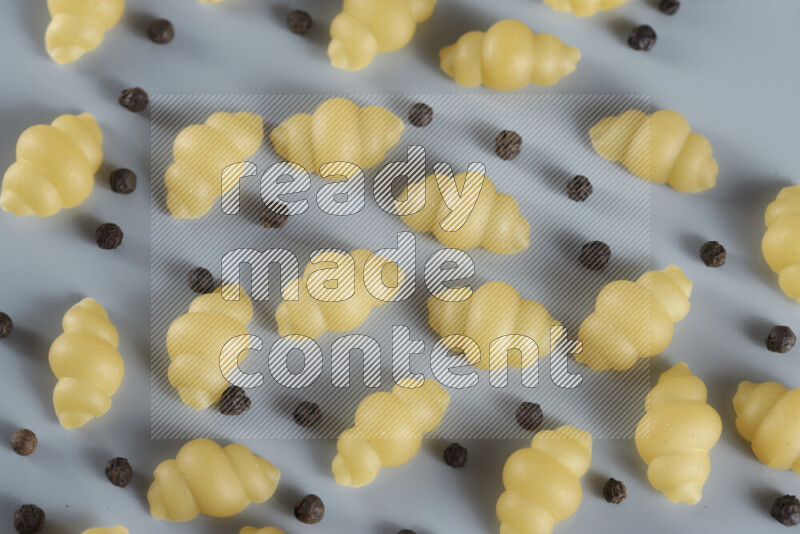 معكرونة مع مكونات متنوعة من الطماطم والثوم والبصل والفلفل الأحمر والفلفل الأسود والفلفل الأبيض وأوراق الغار وإكليل الجبل والهيل و مشروم على خلفية زرقاء فاتحة