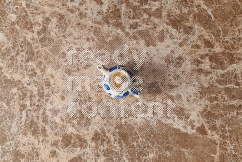 إبريق شاي فخاري على خلفية رخام بيج