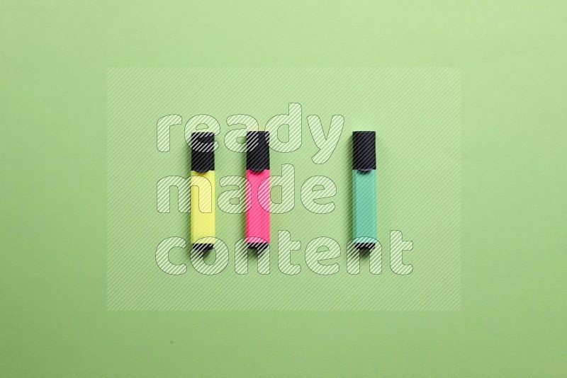 Multicolored highlighter pens on green background (back to school)