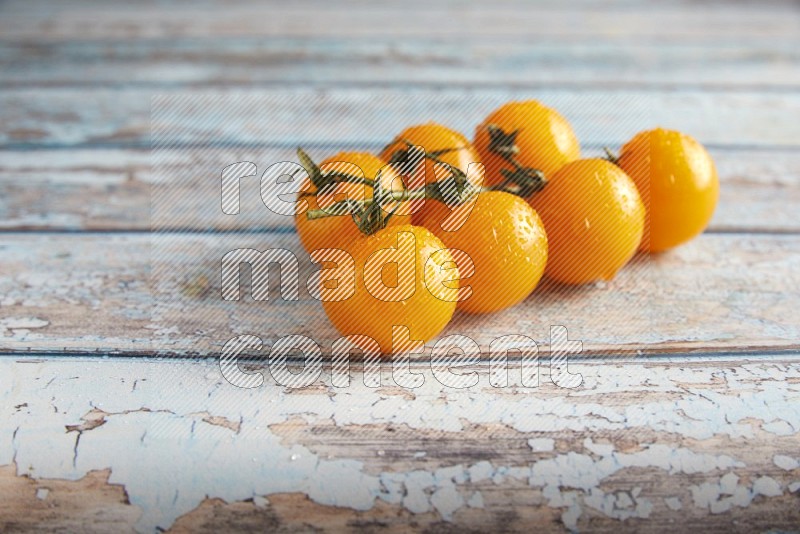 yellow cherry tomato vein on a textured blue wooden background 45 degree