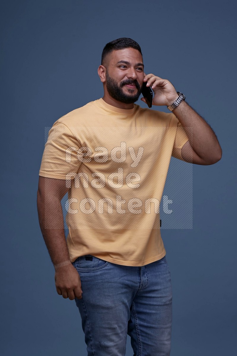A man Calling on Blue Background wearing Orange T-shirt