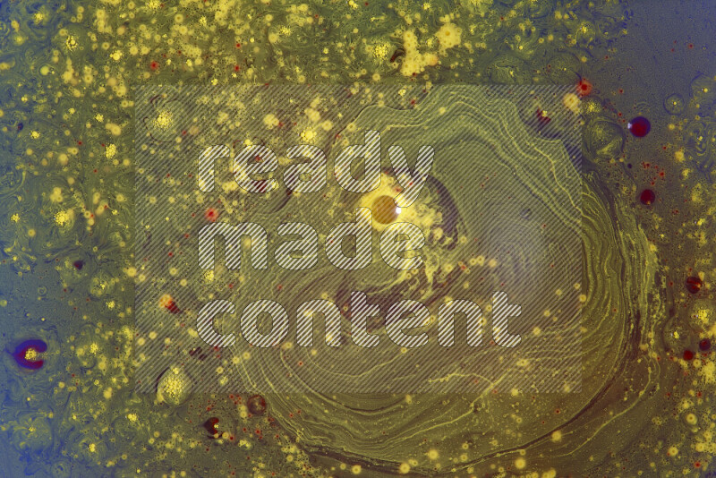 The image captures a dramatic splatter of yellow and red paints over an blue backdrop
