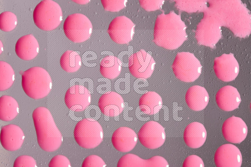 لقطات مقربة لقطرات من اللون الوردي على الخلفية