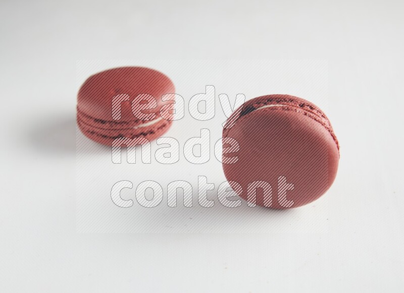 45º Shot of two Red Velvet macarons on white background