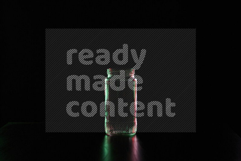 Glassware with rim light in red and green against black background