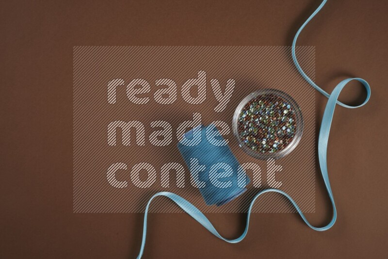 مجموعة من أدوات الخياطة والتفصيل زرقاء اللون على خلفية بنية