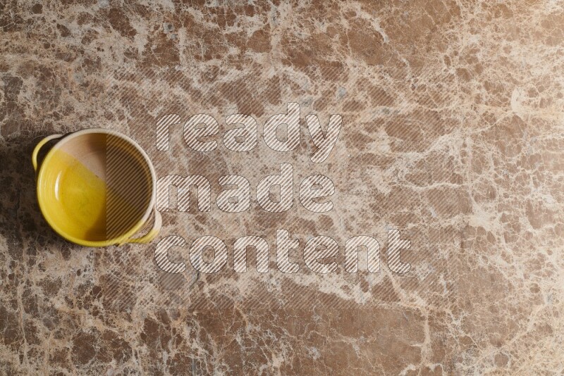 A multicolored pottery bowl on beige marble background