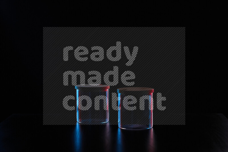 Glassware with rim light in red and blue against black background