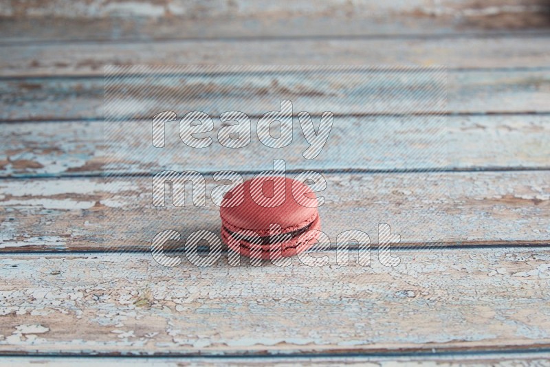 45º Shot of Pink Raspberry macaron on light blue wooden background