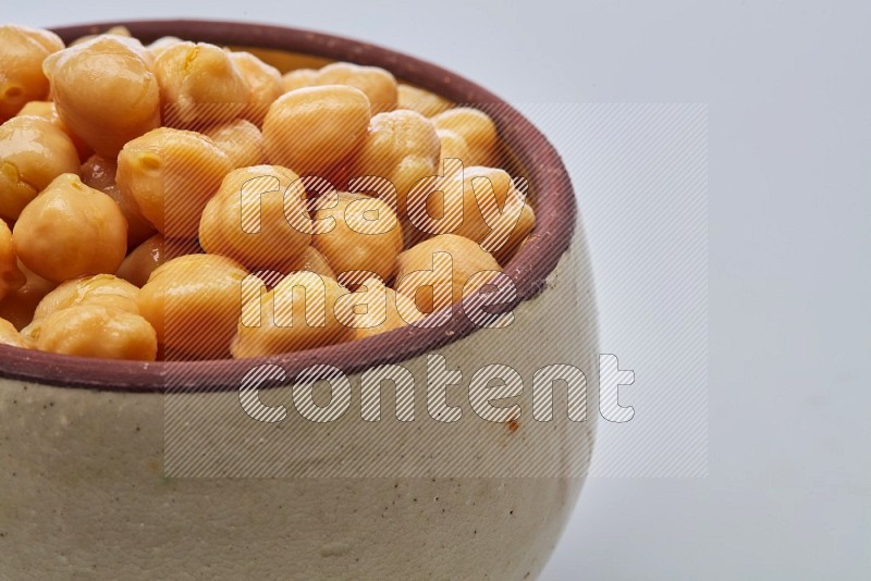 Close up shot of boiled chickpeas in a container on white background