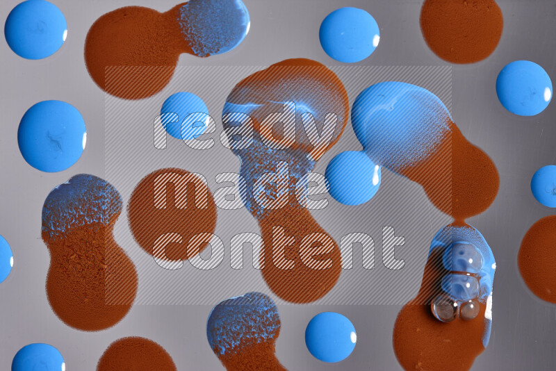 Close-ups of abstract orange and blue paint droplets on the surface