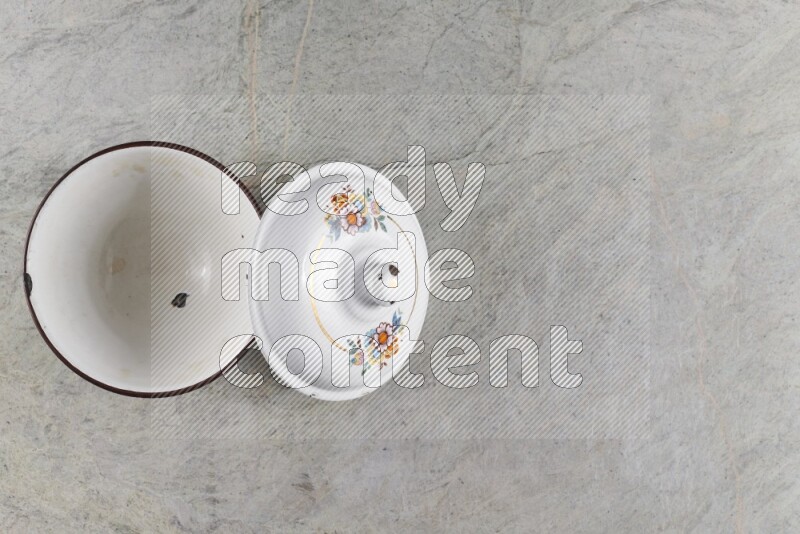 A vintage metal pot on grey marble background