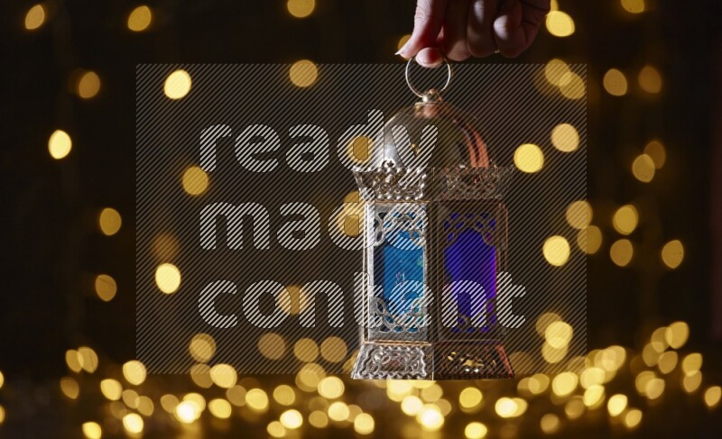 A traditional ramadan lantern surrounded by glowing fairy lights in a dark setup