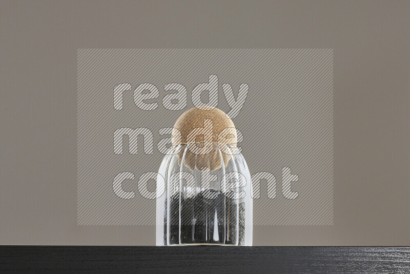 قراصيا مجففة في وعاء زجاجي على خلفية سوداء