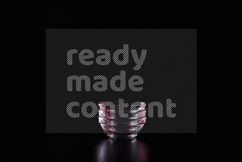 Glassware with rim light in red and white against black background