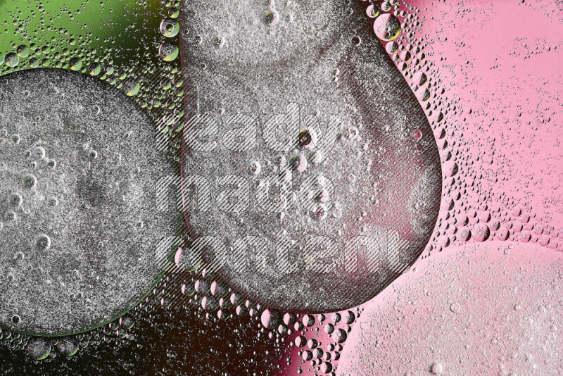 Close-ups of abstract oil bubbles on water surface in shades of green and pink