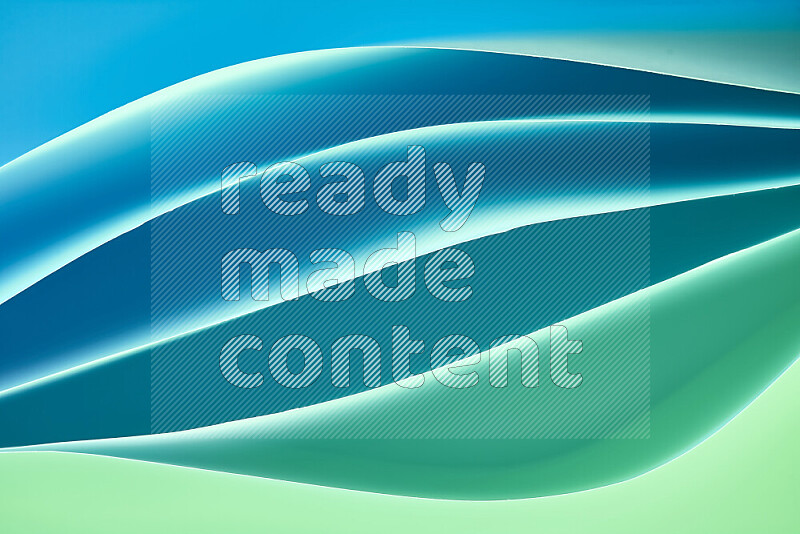 This image showcases an abstract paper art composition with paper curves in green and blue gradients created by colored light