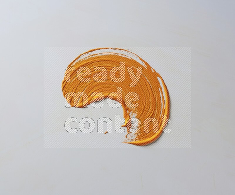 An orange curved painting brush stroke on a white background