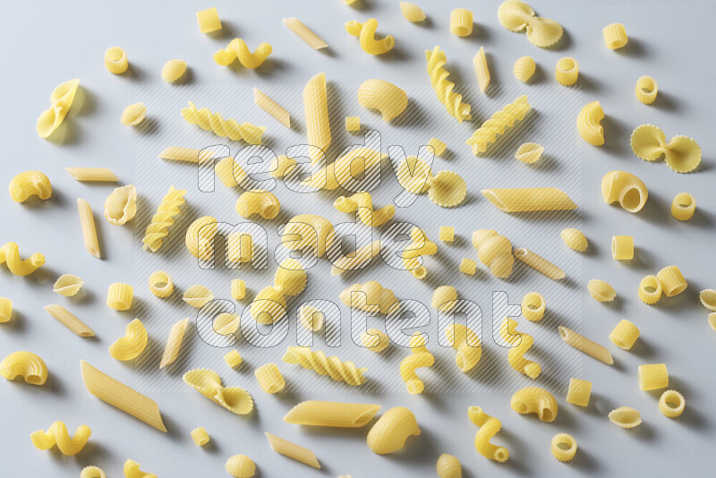 Different pasta types on light blue background