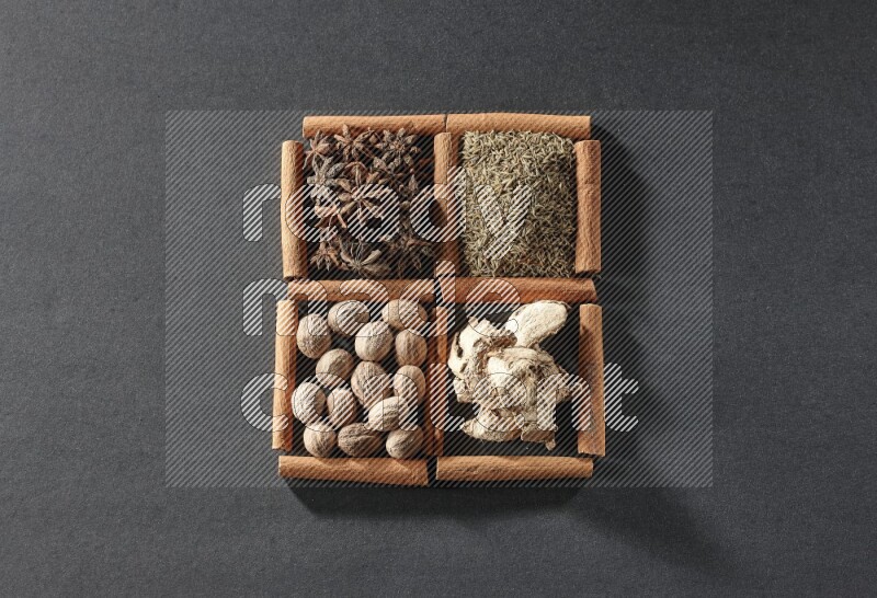 4 squares of cinnamon sticks full of star anise, cumin, dried ginger and nutmegs on black flooring