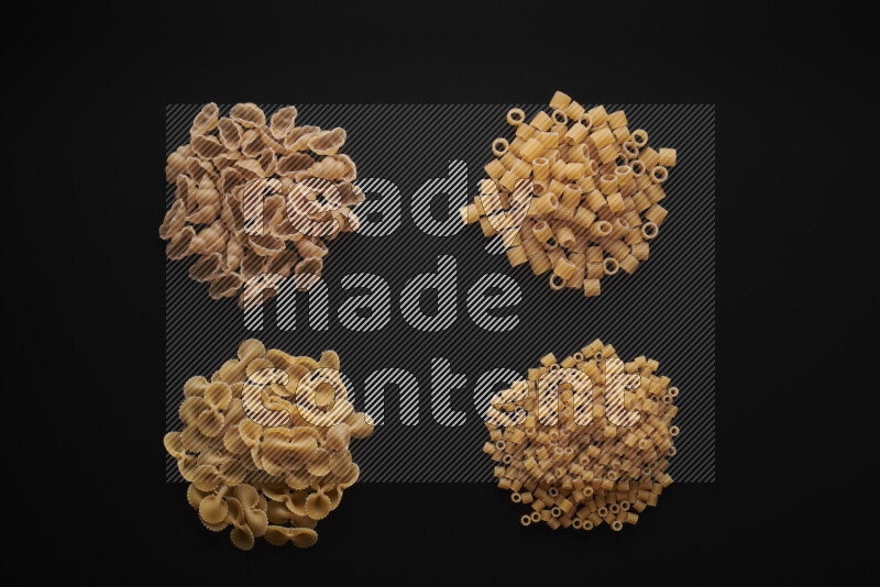 Different pasta types in bunches on black background