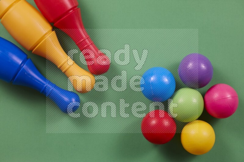 أوتاد البولينج البلاستيكية مع الكرات علي خلفيات ملونة مختلفة (ألعاب أطفال)