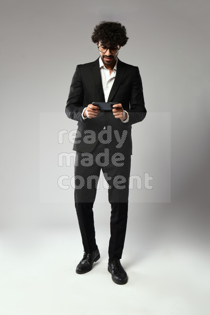 رجل يرتدي ملابس رسمية يلعب علي الهاتف علي خلفية بيضاء