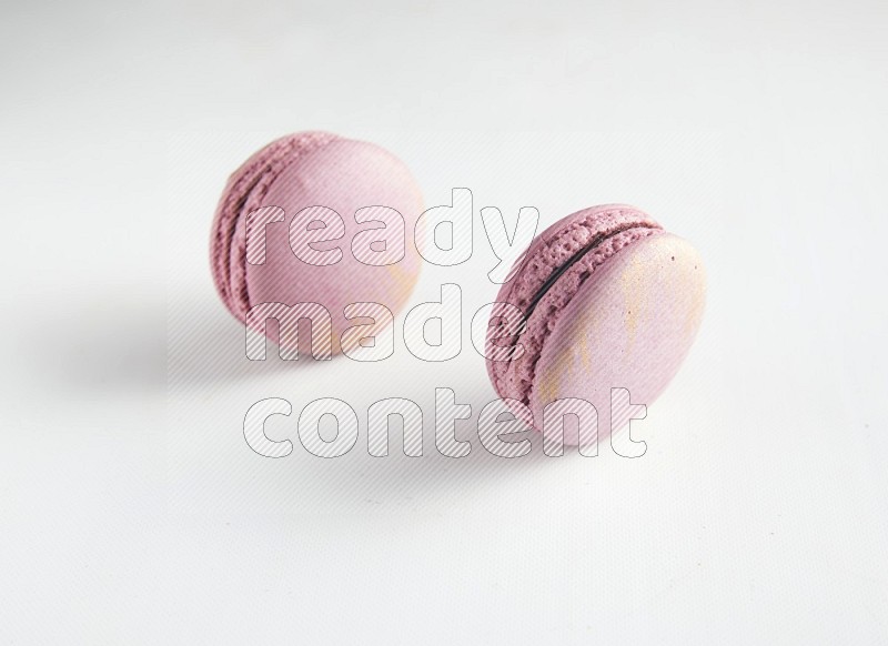 45º Shot of two Purple Strawberry macarons on white background