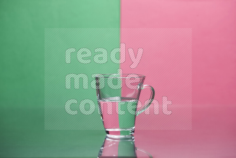 The image features a clear glassware filled with water, set against green and pink background