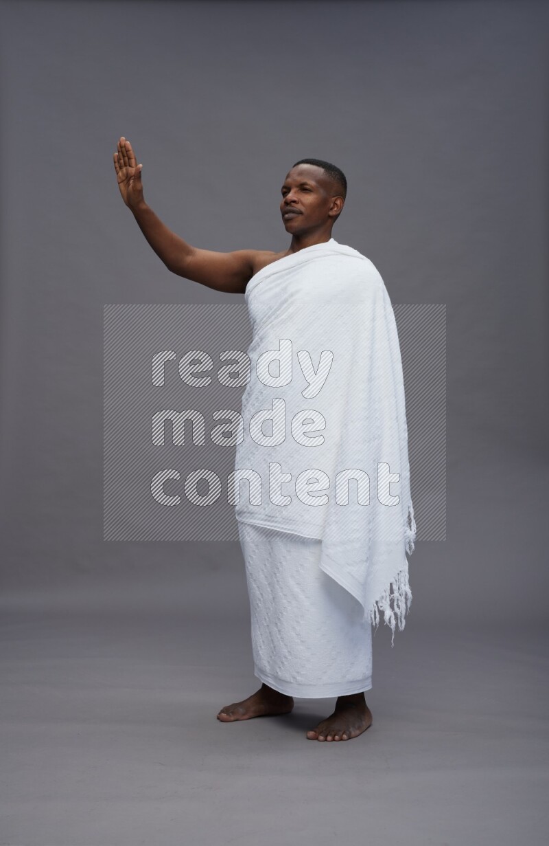 A man wearing Ehram Standing Interacting with the camera on gray background