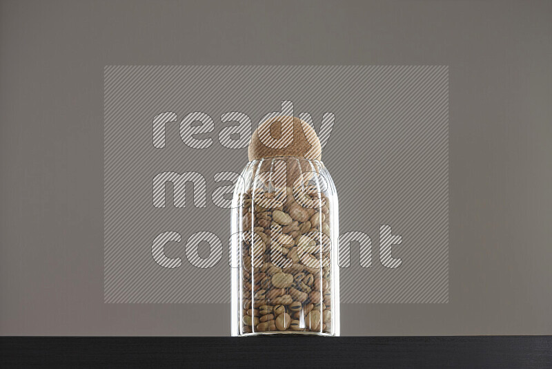 Fava beans in a glass jar on black background