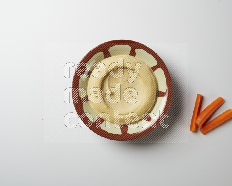 Plain hummus in a traditional plate on a white background