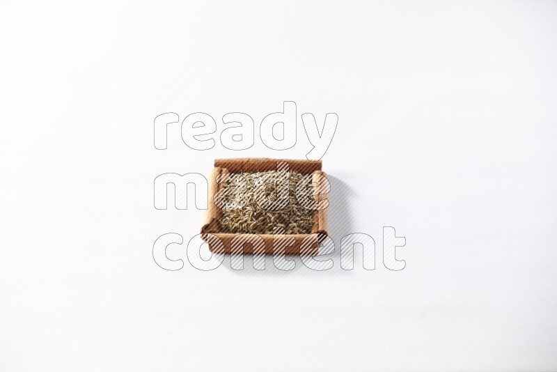 A single square of cinnamon sticks full of cumin on white flooring