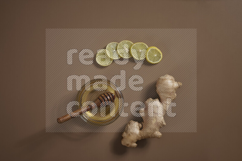 Fresh ginger root with different ingredients such as lemon, orange, honey, ground ginger on beige baackground