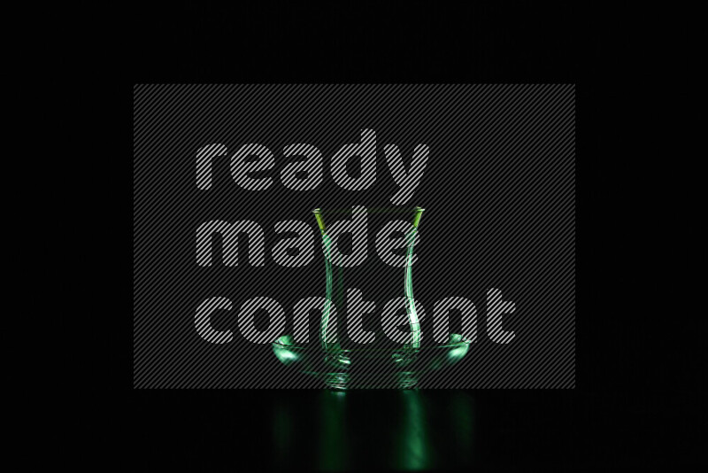 Glassware with rim light in green against black background