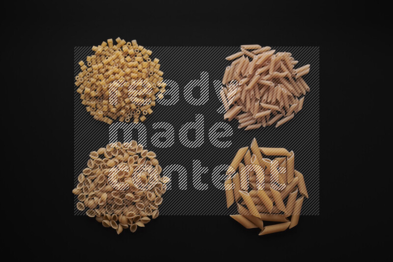 Different pasta types in bunches on black background